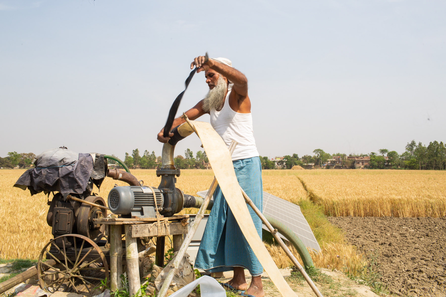 man handling water pump in field