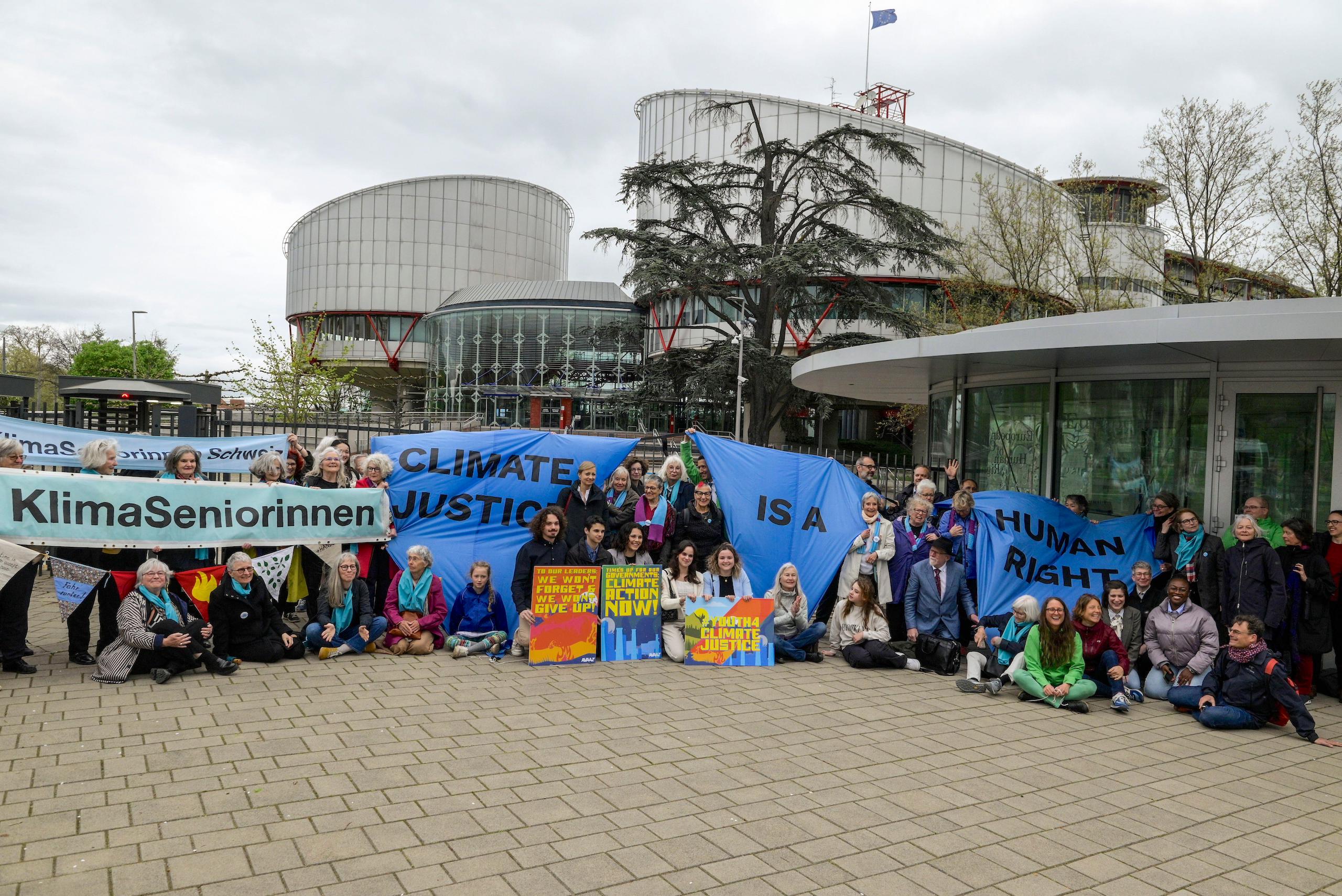 A group of people holding up a sign protesting in front of a building