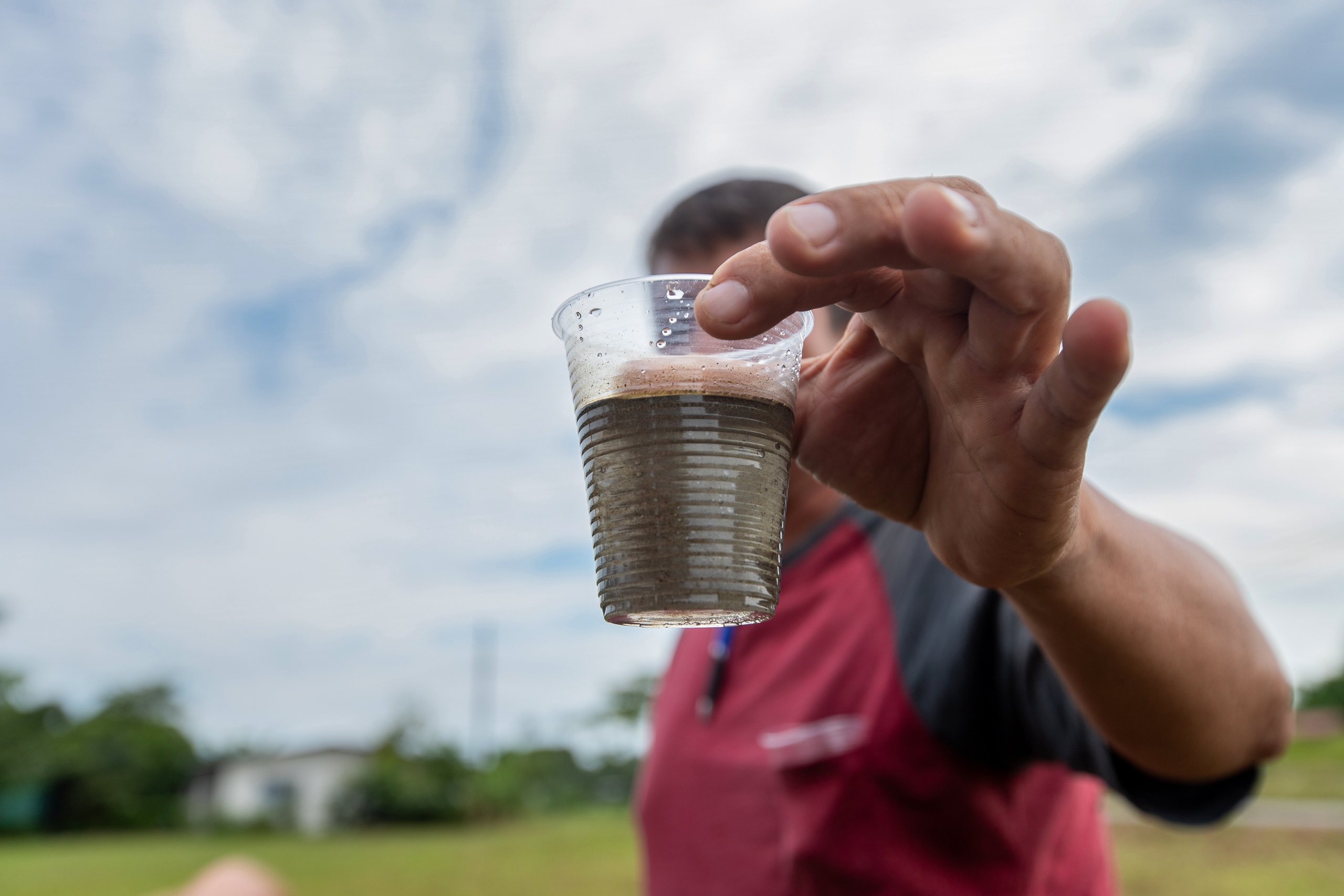 un hombre con un vaso de agua de pozo en la mano