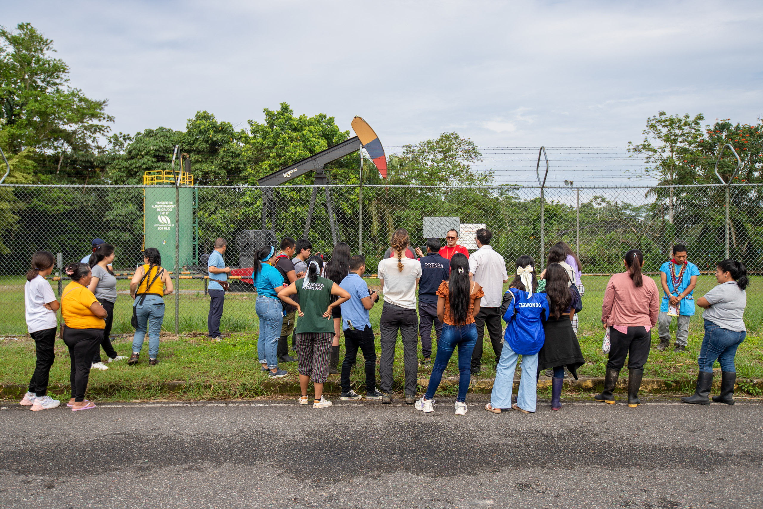 Un grupo de personas frente a una excavadora de petróleo