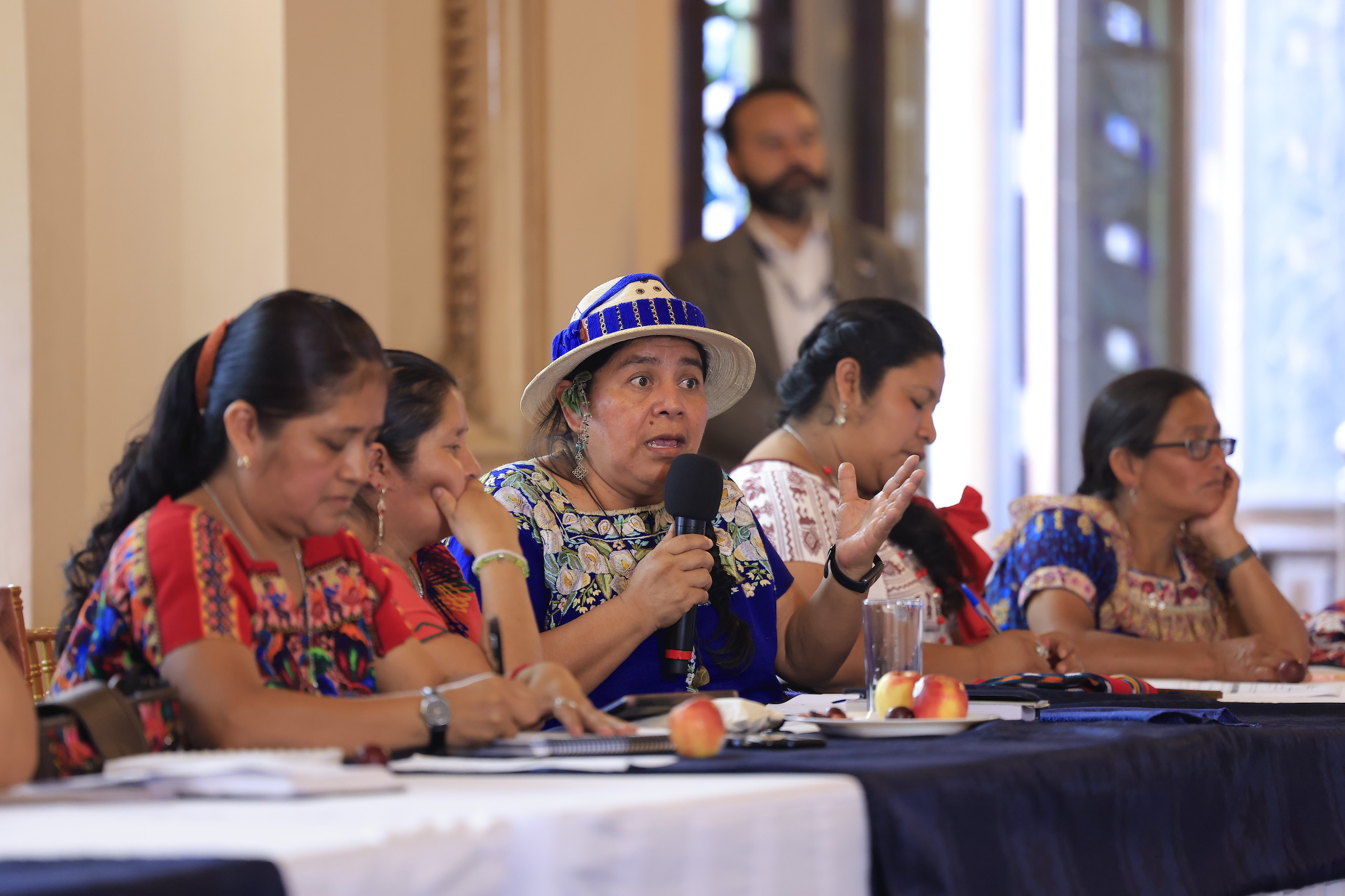 A group of women engaged in discussion at a conference