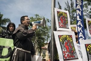 A man with a megaphone and signs, engaging an audience