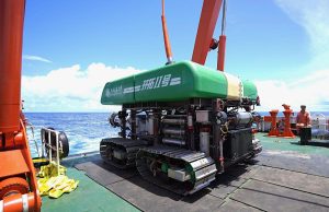 a deep sea heavy duty mining vehicle on the deck of a ship