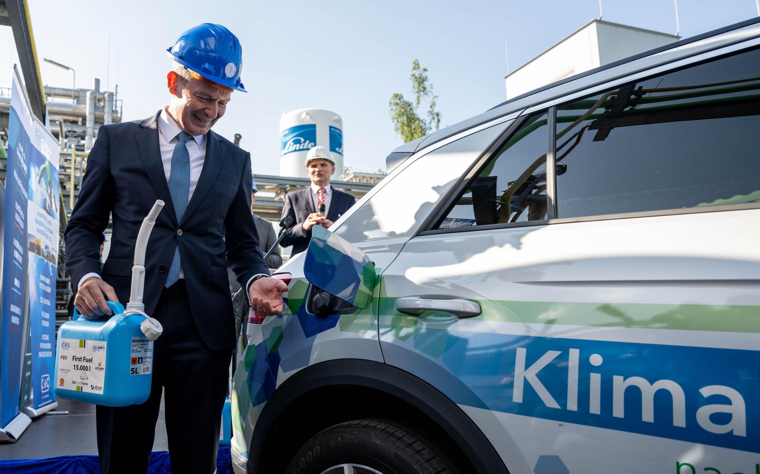 a man filling a car with electrofuel