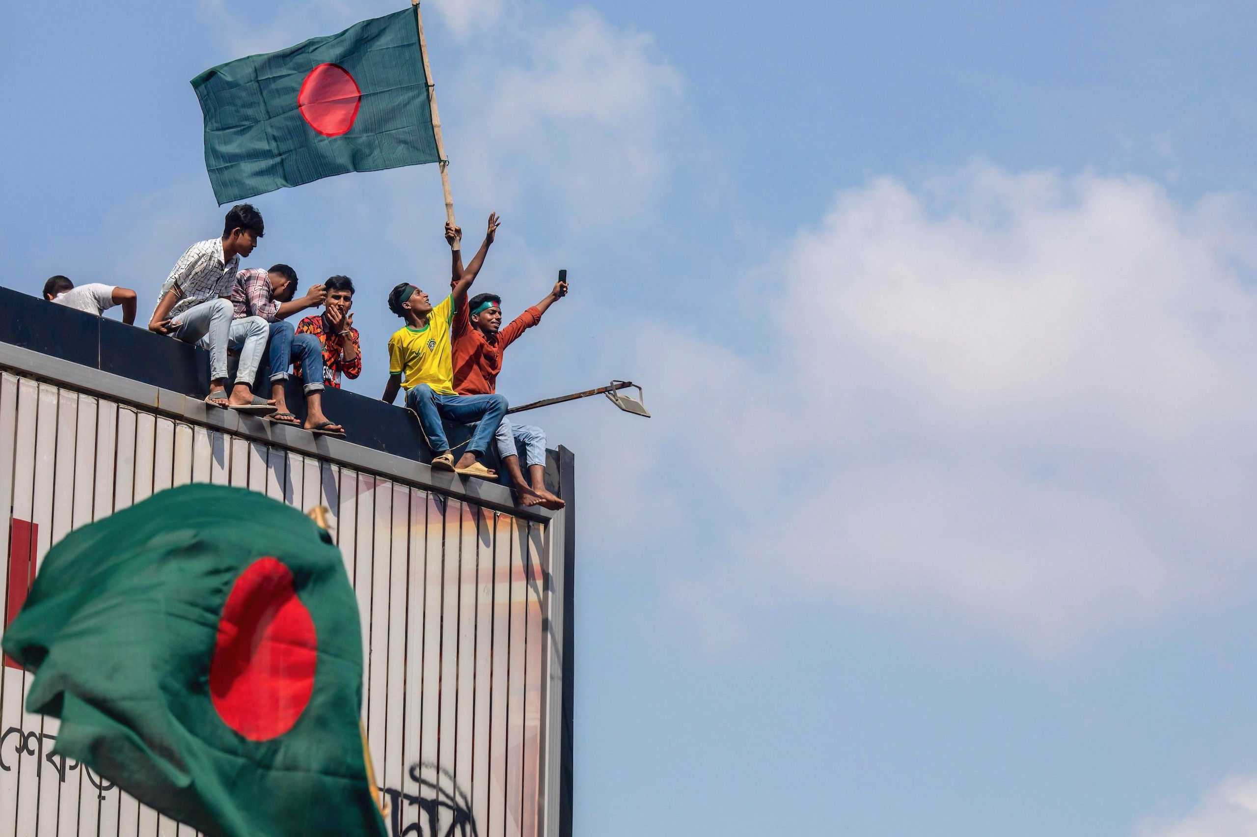 <p>Protestors wave Bangladesh flags in Shahbag near Dhaka University, celebrating Prime Minister Sheikh Hasina&#8217;s resignation after student-led protests against hiring rules culminated on August 5. (Image: SOPA Images / Alamy)</p>