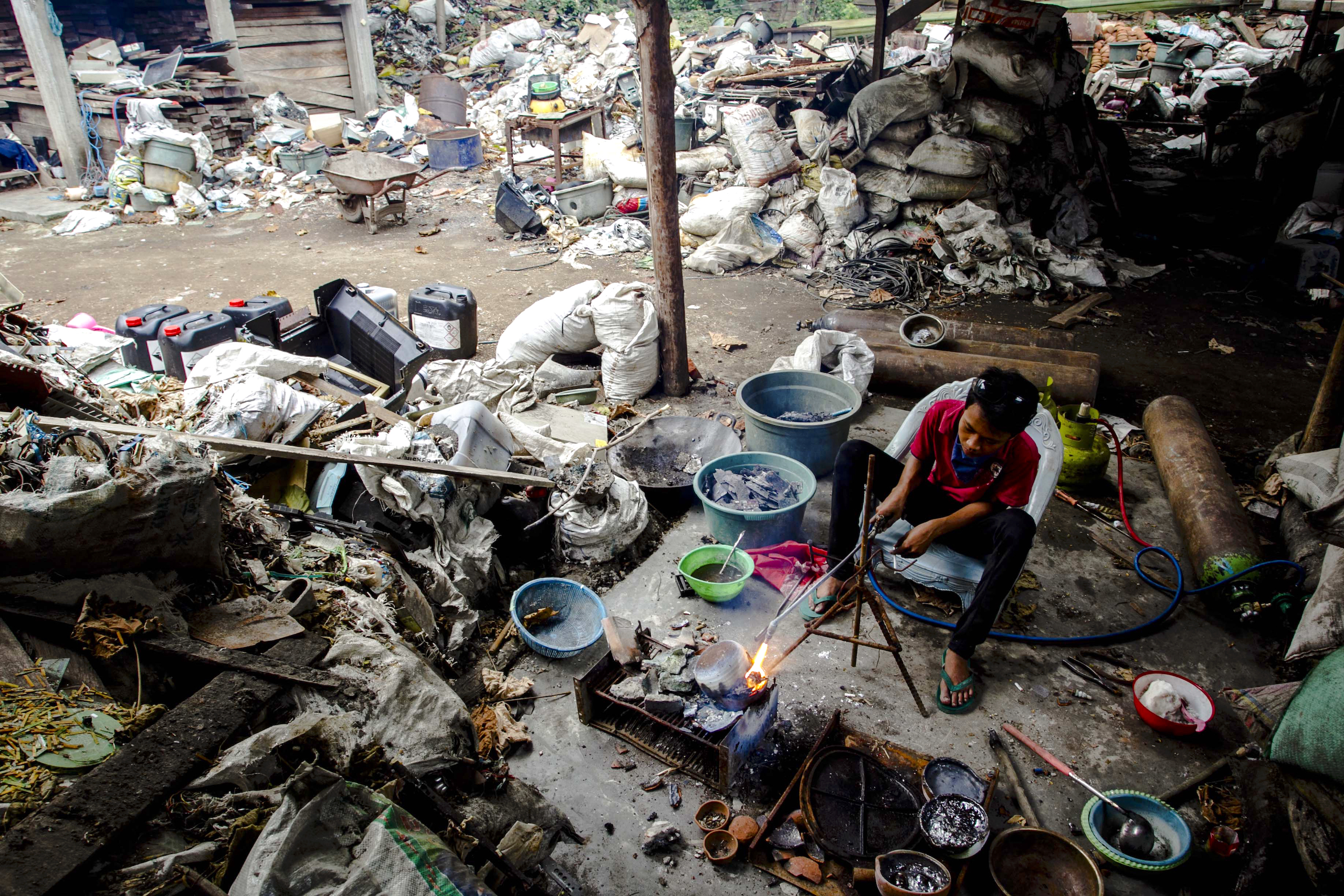 a worker smelts electronic waste at a recycling centre