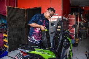 a man replaces electric motor battery at a workshop