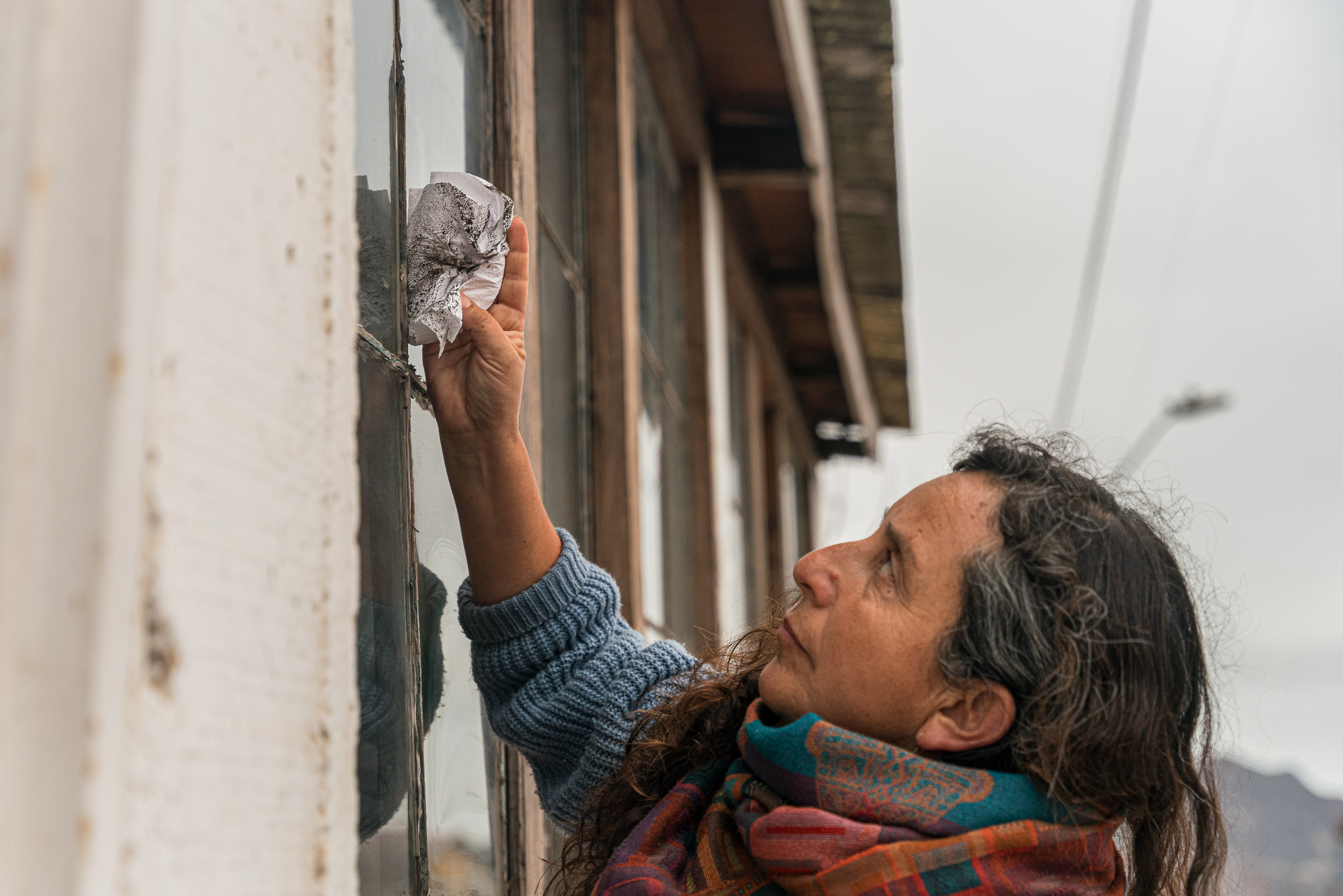 woman using cloth to clean window