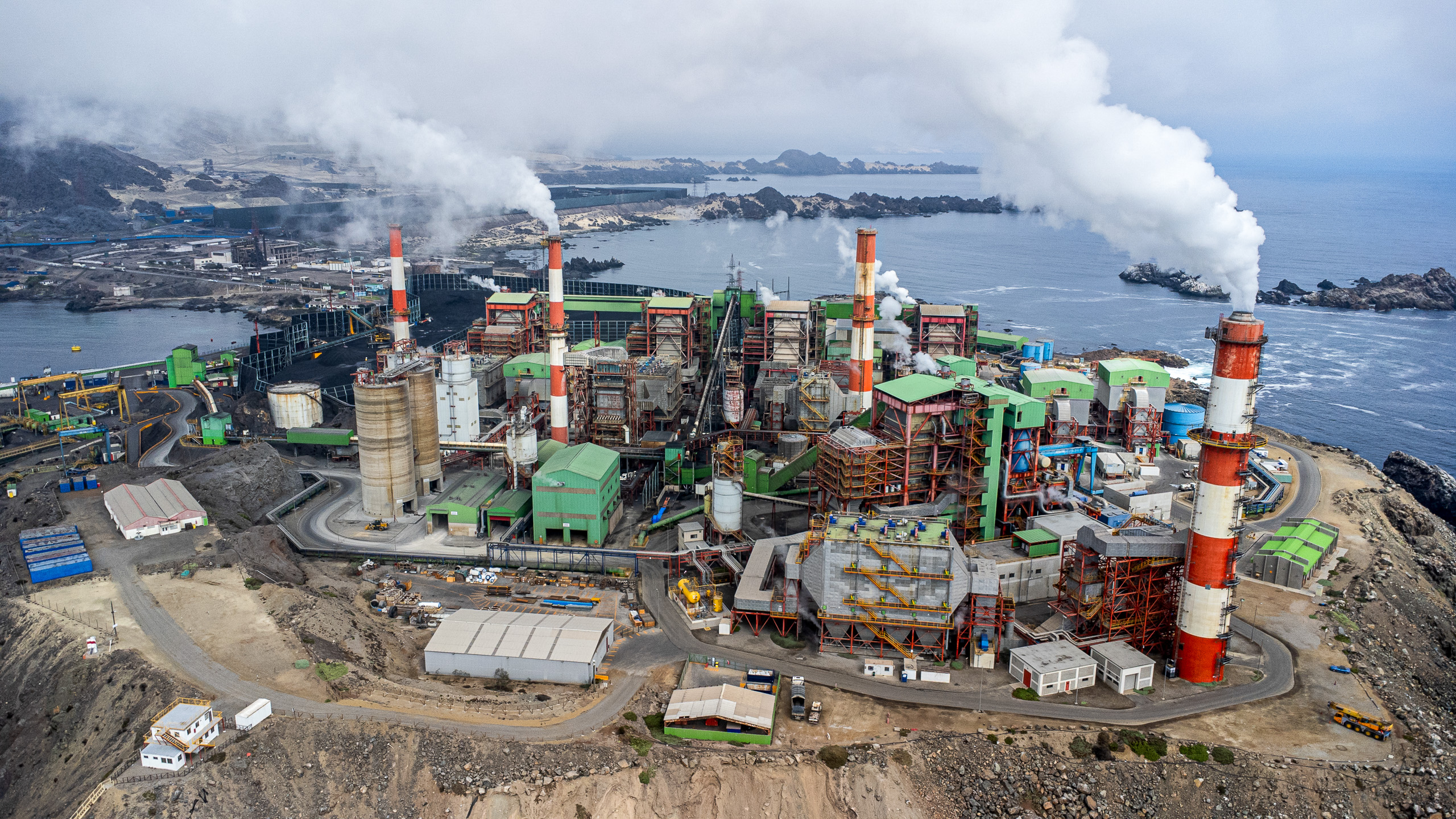 large industrial complex including smoking towers on coast 