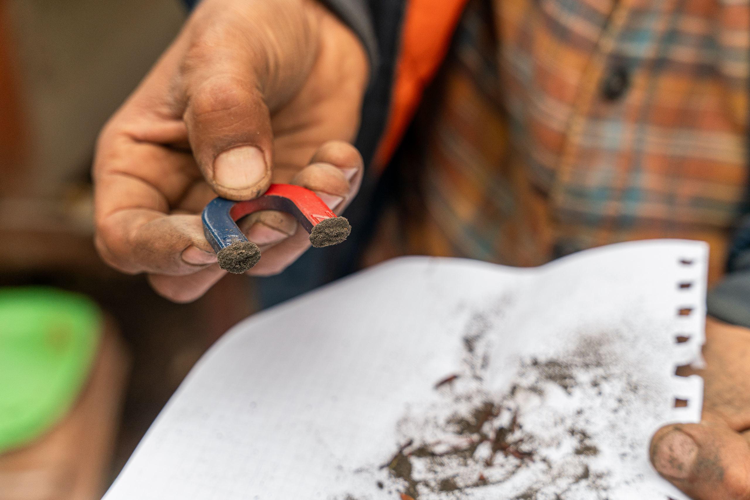 handheld magnet over dust covered paper