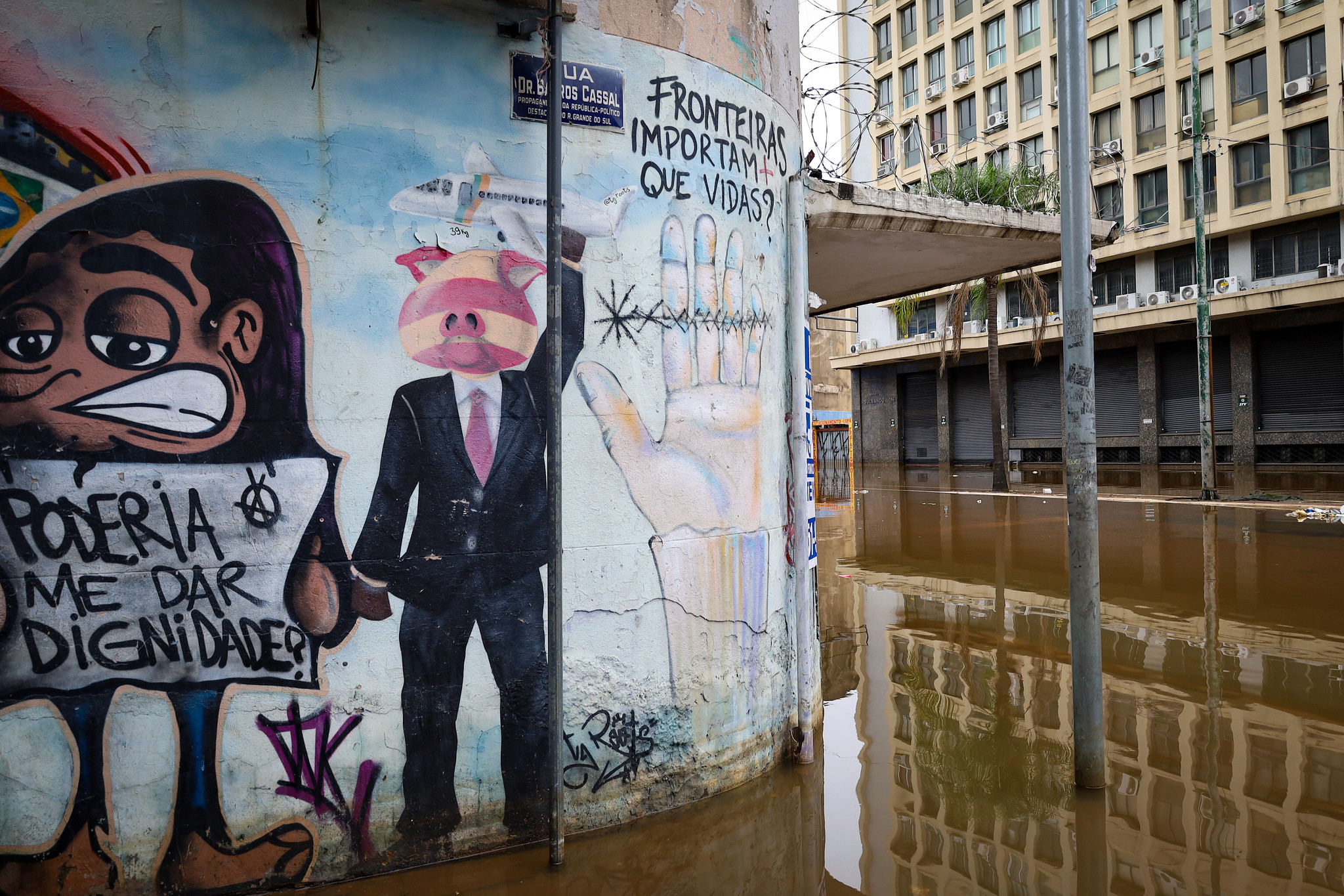 Grafite nas ruas alagadas do Centro Histórico de Porto Alegre com a frase ‘Poderia me dar dignidade?’