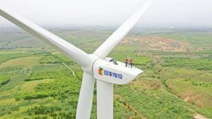 two people standing atop wind turbine