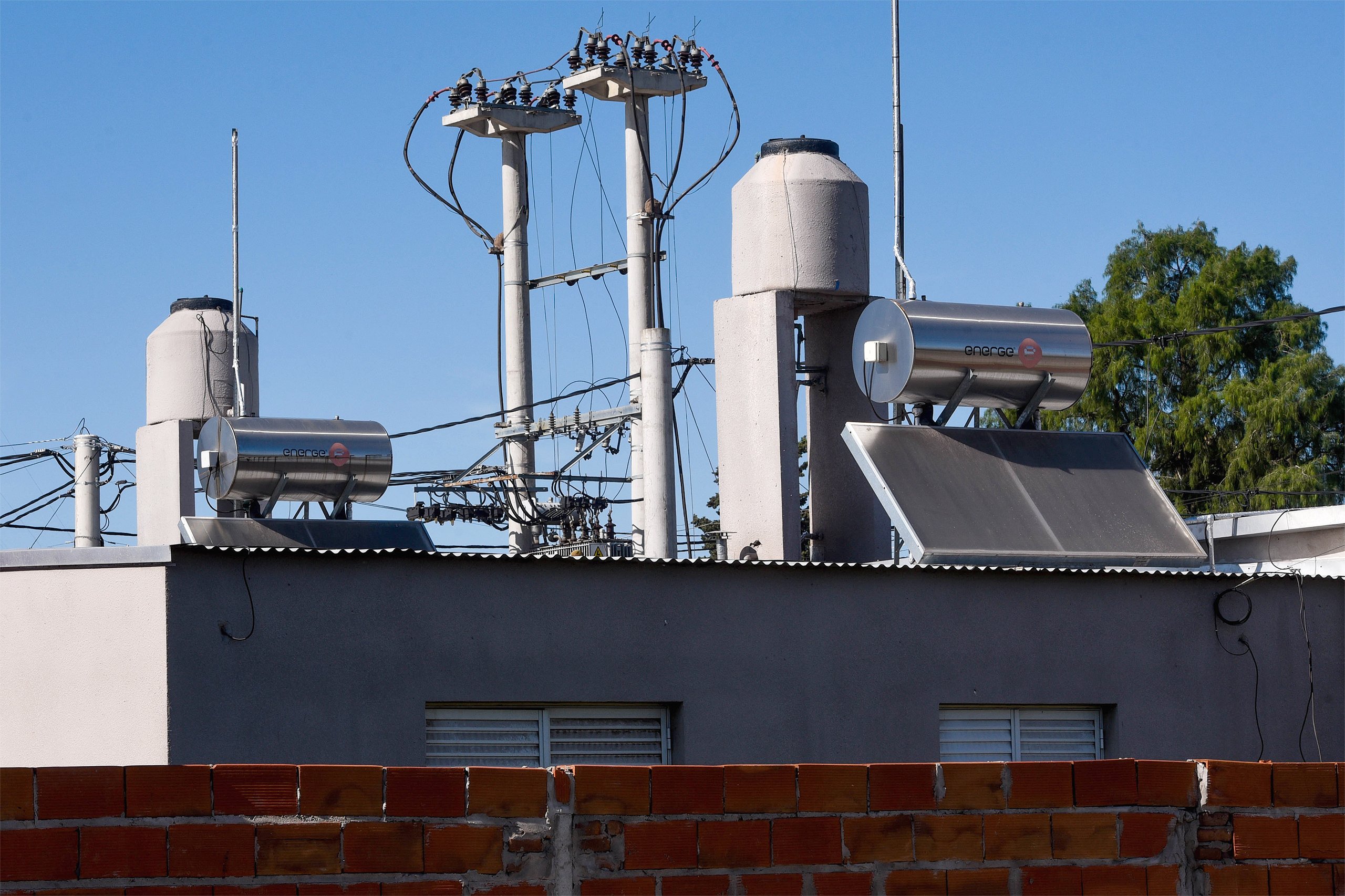 Aquecedores solares no teto de casas de tijolo à mostra em um bairro pobre de Rosário, Argentina