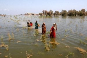 Women wade through floodwaters