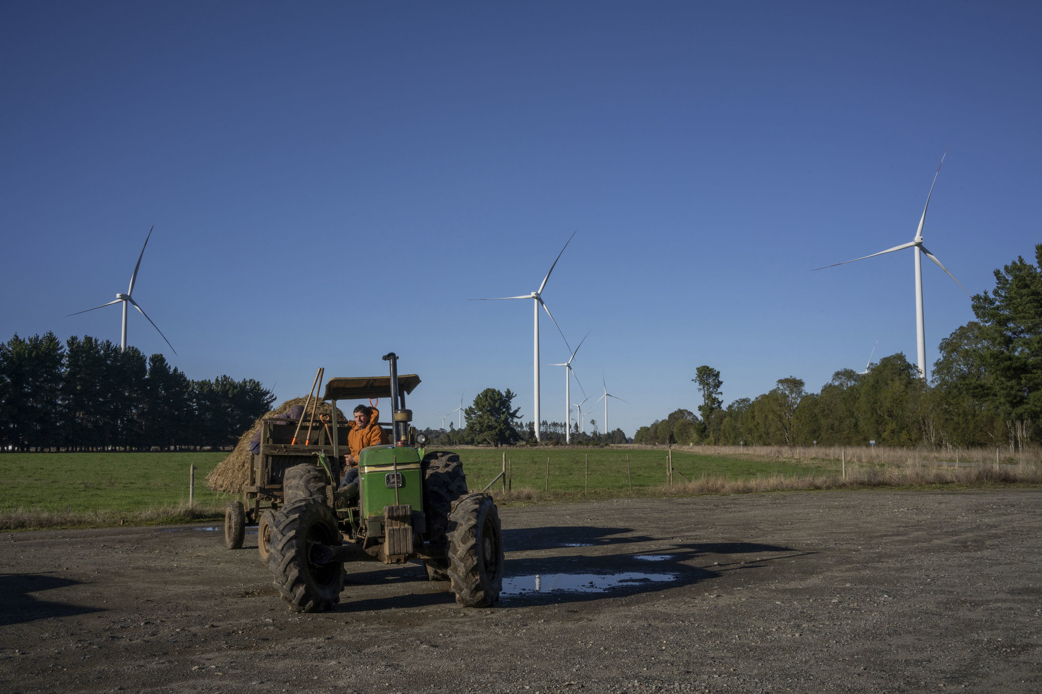 un tractor cerca de un parque eólico