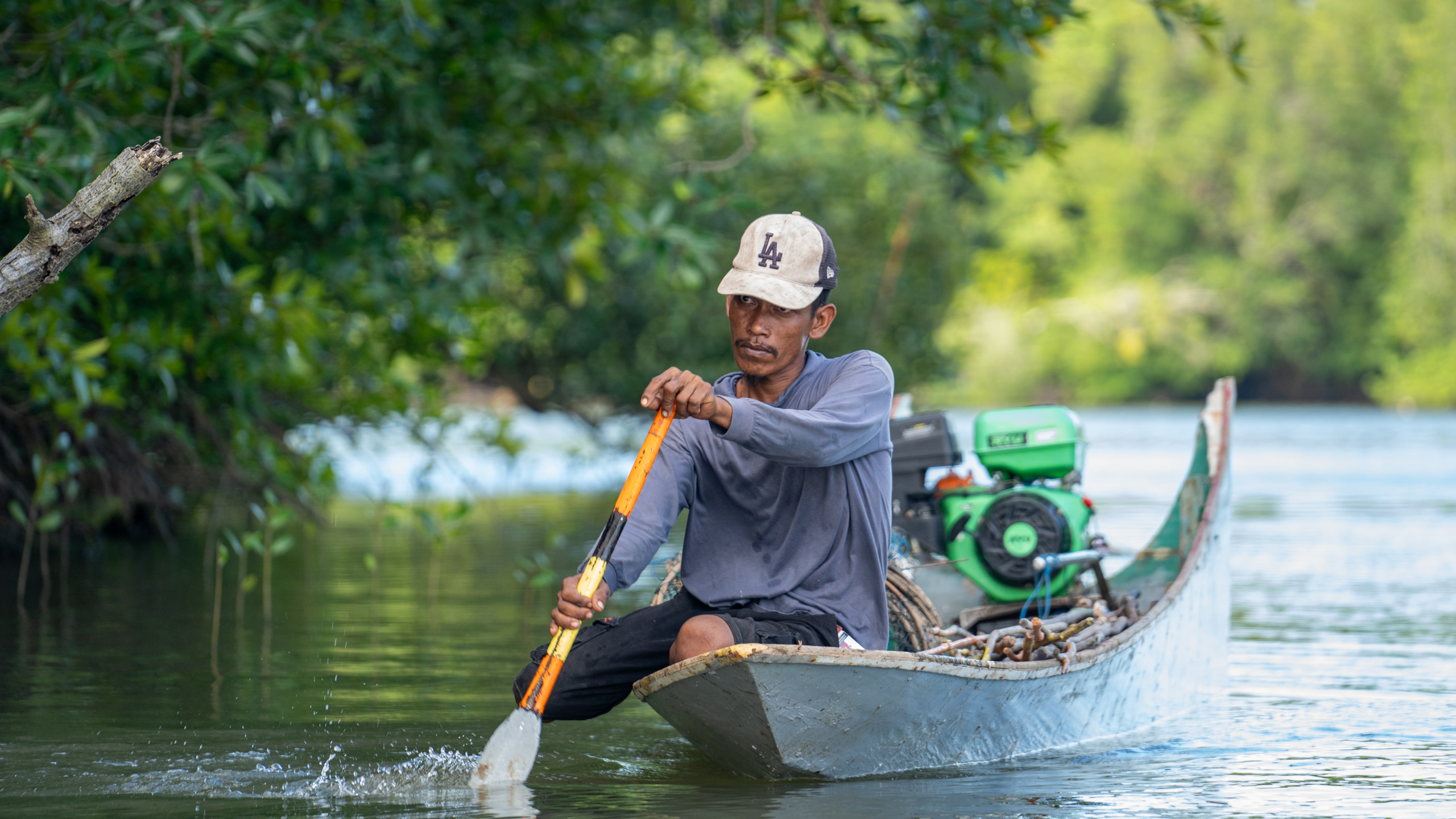 A man paddles a boat along a river