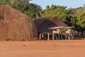 A man walks past a hut