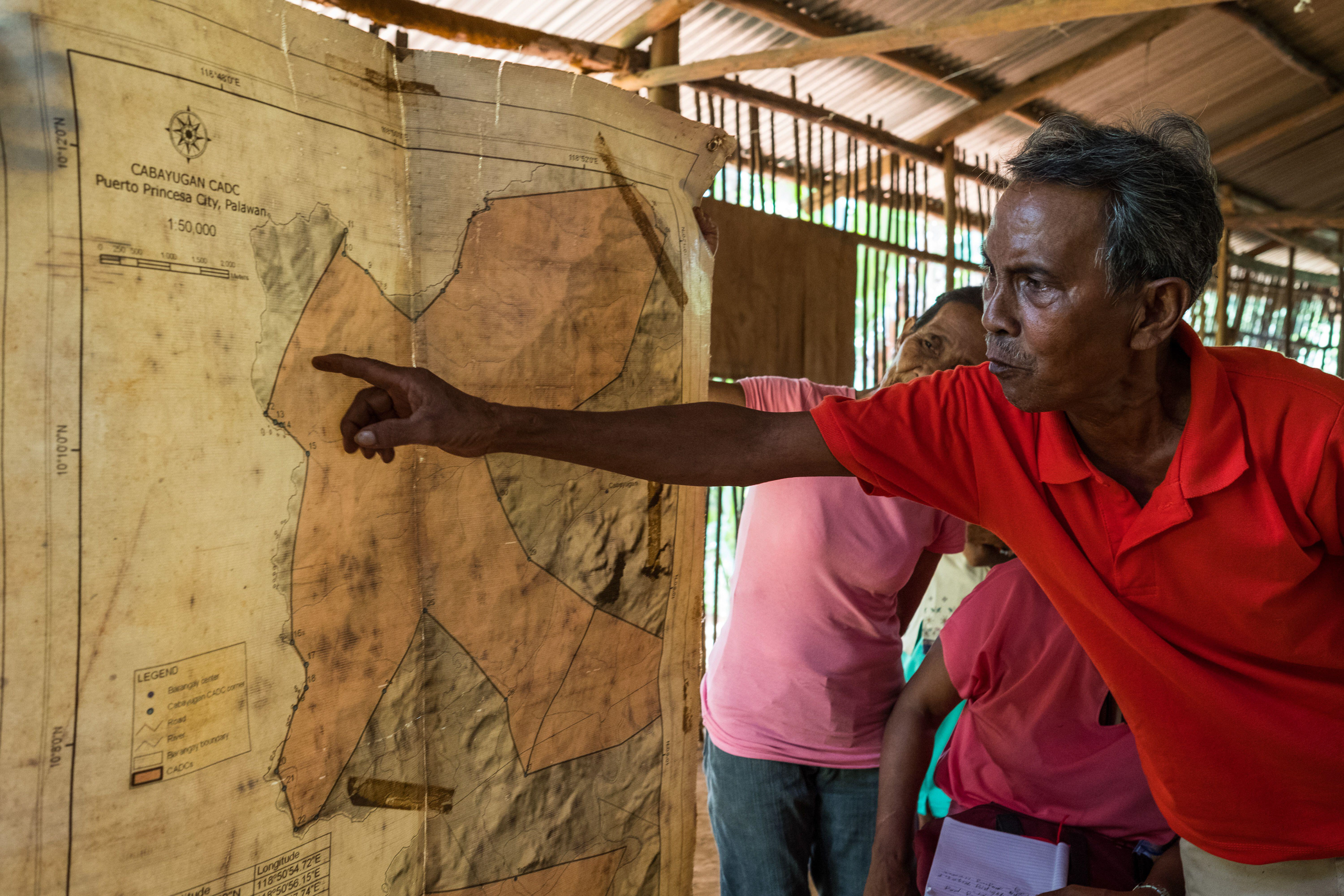 man pointing to map on wall