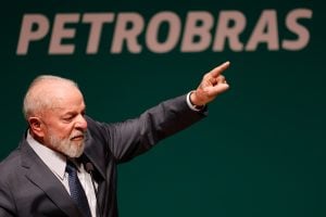 Lula da Silva con su brazo izquierdo levantado, delante de la inscripción "Petrobras"