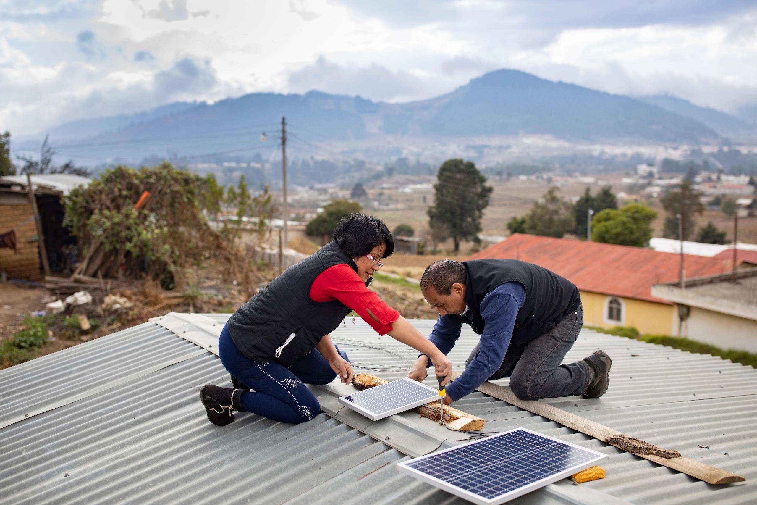 Técnicos instalam sistema elétrico alimentado por painéis solares em Cantel, Guatemala