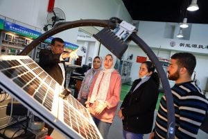 A teacher talks to several students at a photovoltaic workshop