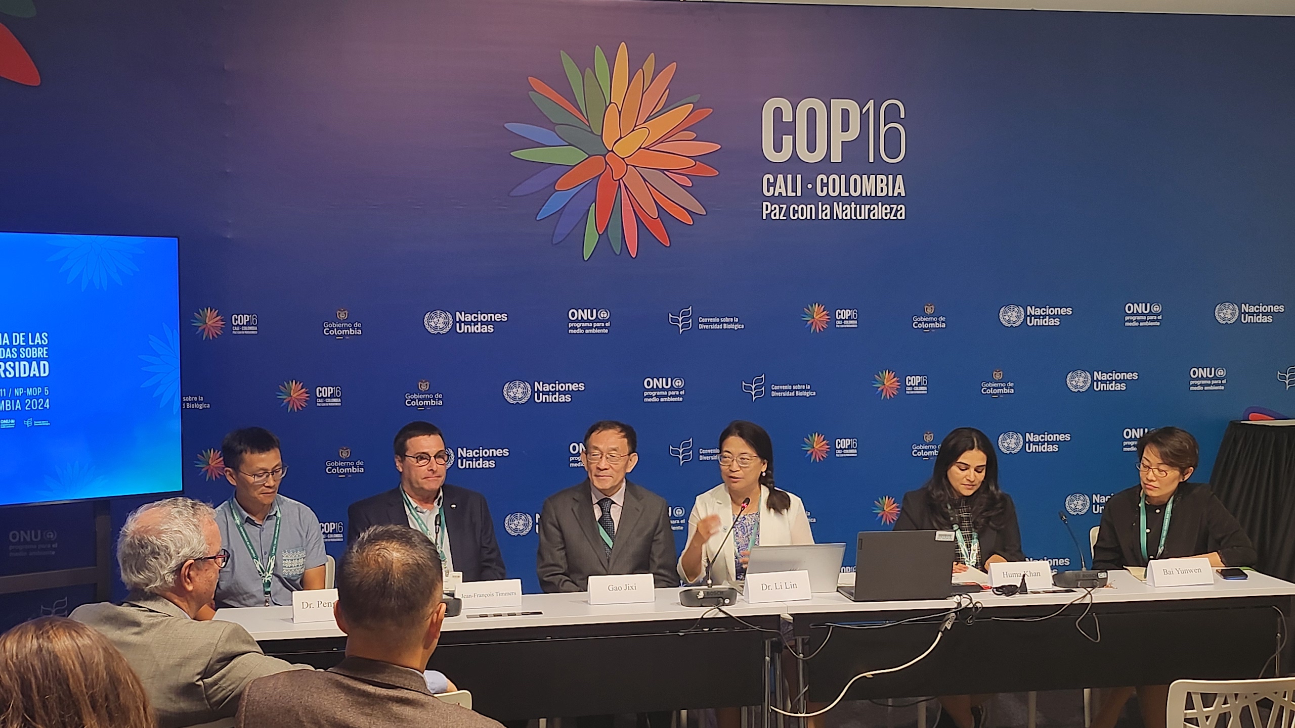 Varias personas sentadas a una mesa en una sala de conferencias