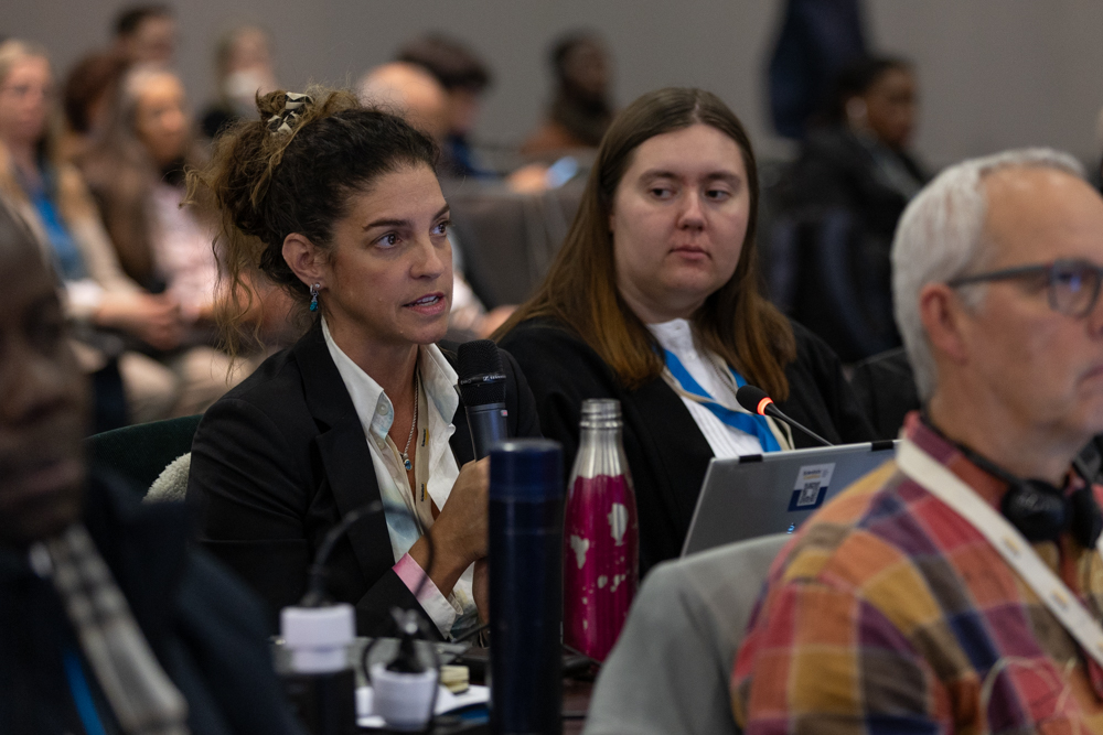 a woman in suits speaks at a conference
