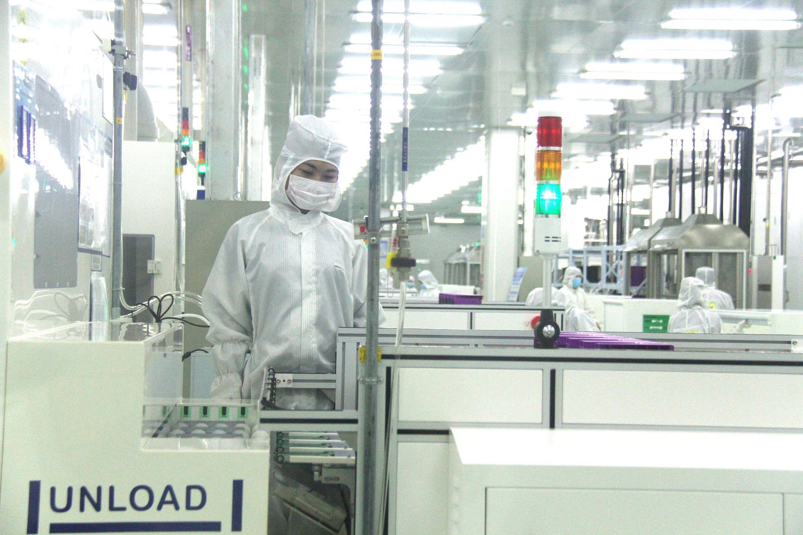 A factory worker operates a machine