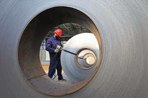 a worker is striping the steel production line