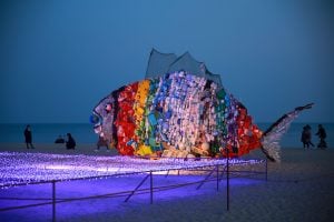 large fish shaped sculpture on dark beach