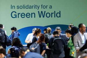 A group of people standing in line at an event about green world