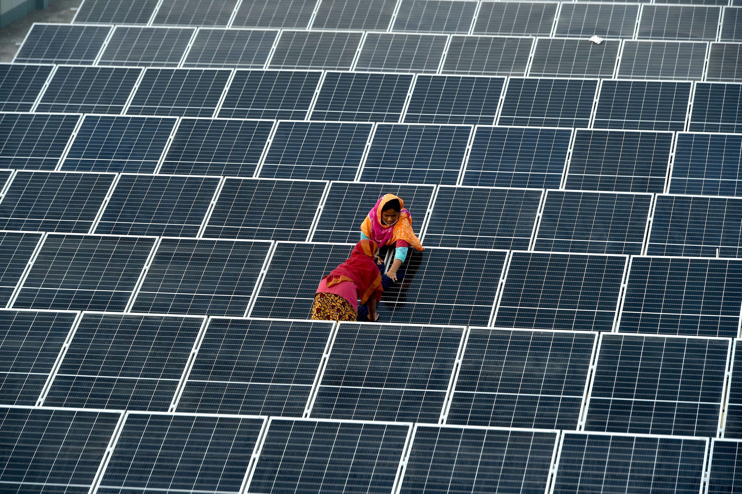 <p style="text-align: left;">Two women install solar panels on a factory building in Gazipur on the outskirts of Bangladesh&#8217;s capital, Dhaka. The Bangladesh Power Development Board is preparing to float tenders for the development of 10 grid-connected solar power plants in the private sector, each with a capacity of 50 MW (Image: Imago / Alamy)</p>