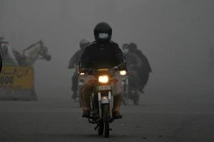 Motorcyclists move with headlights on the road