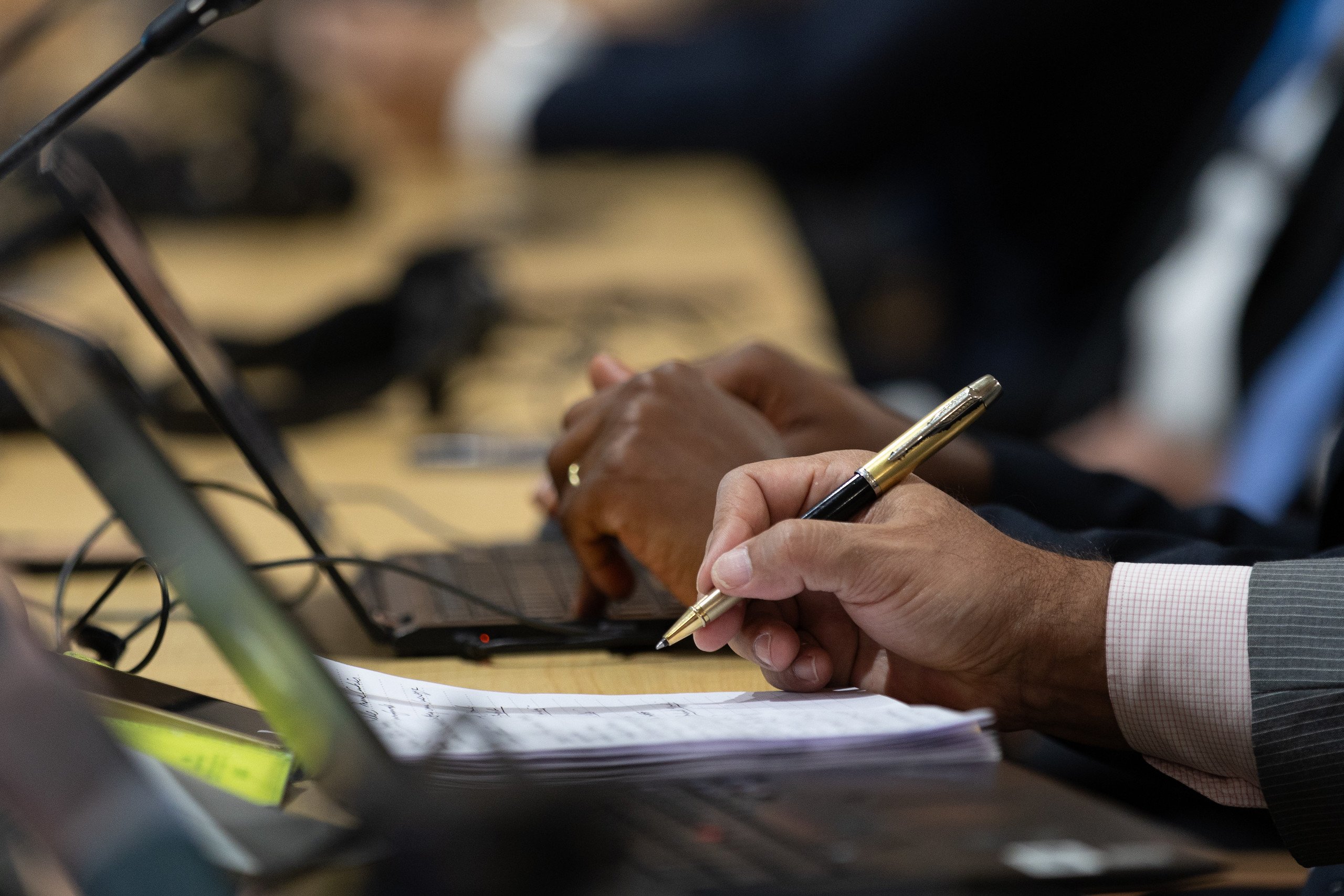 A man holding a pen and writing on a piece of paper