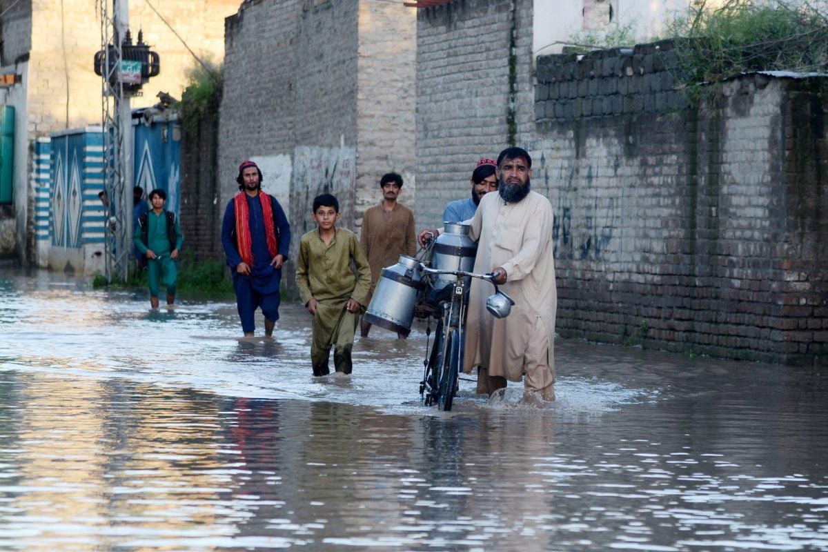 people walking through flood water