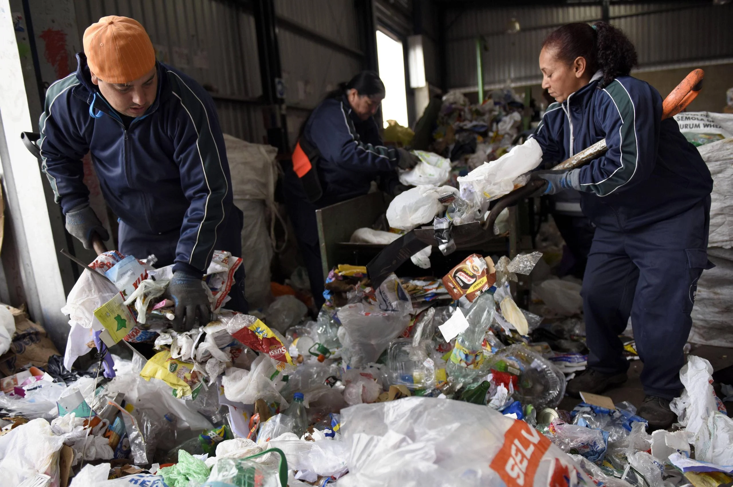 trabajadores clasificando basura en una planta