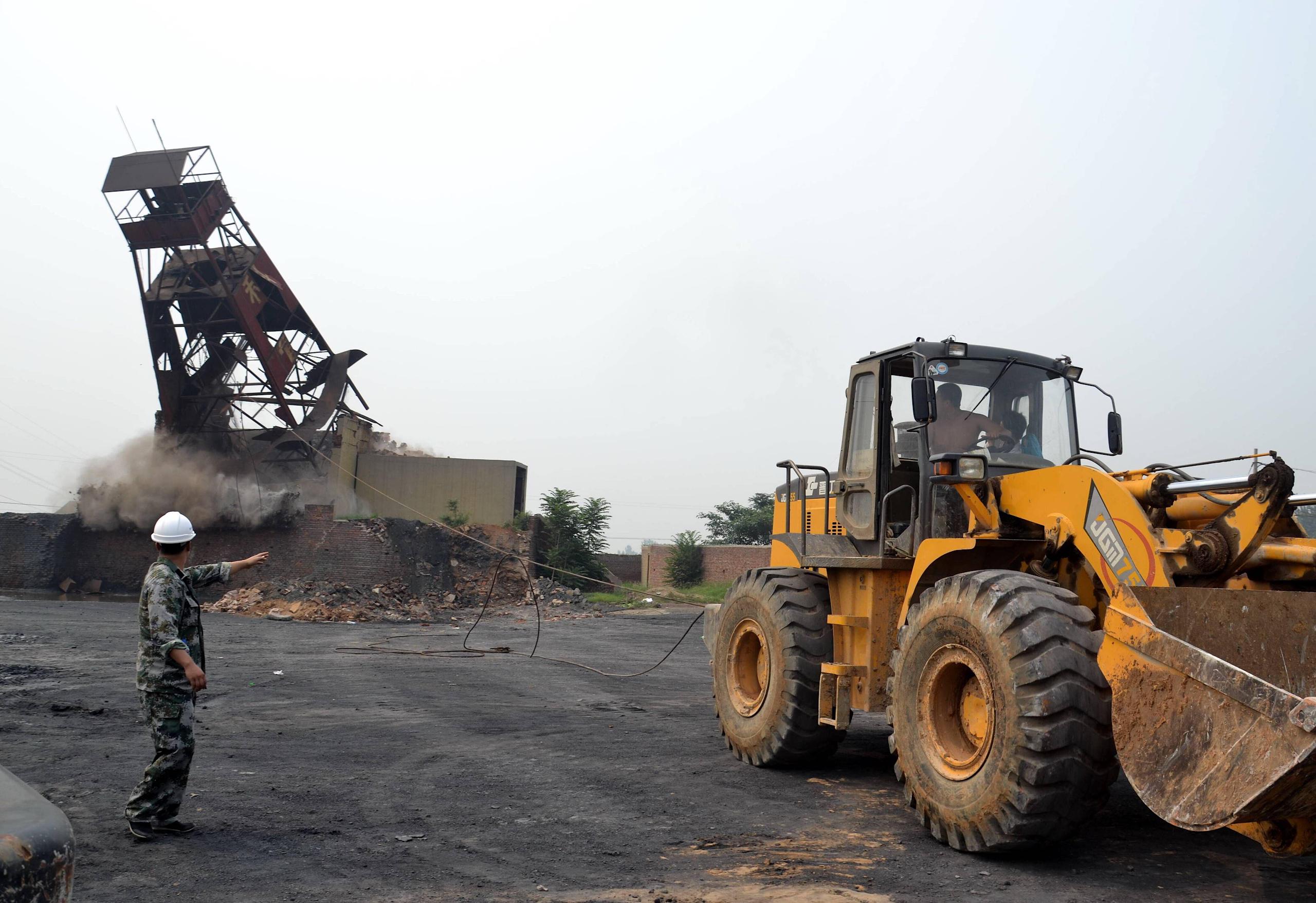 a man gives instructions to dismantle a small tower by a bulldozer