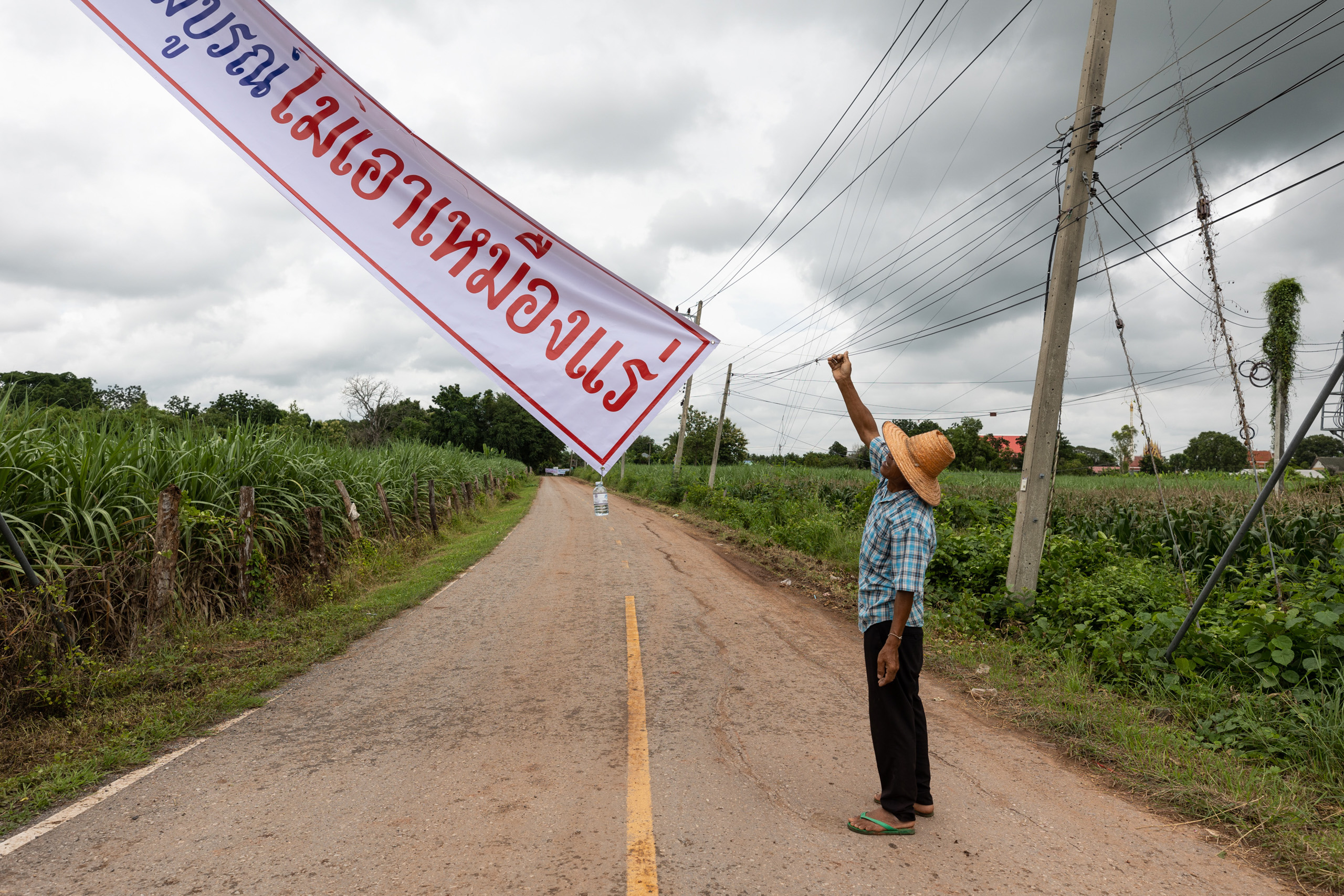 Homem pendura faixa anti-potássio na estrada