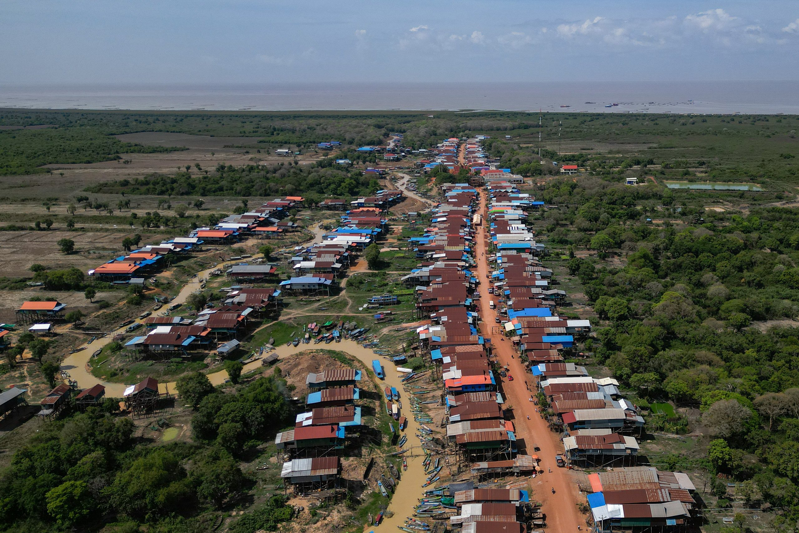 A large cluster of houses with trees and a road