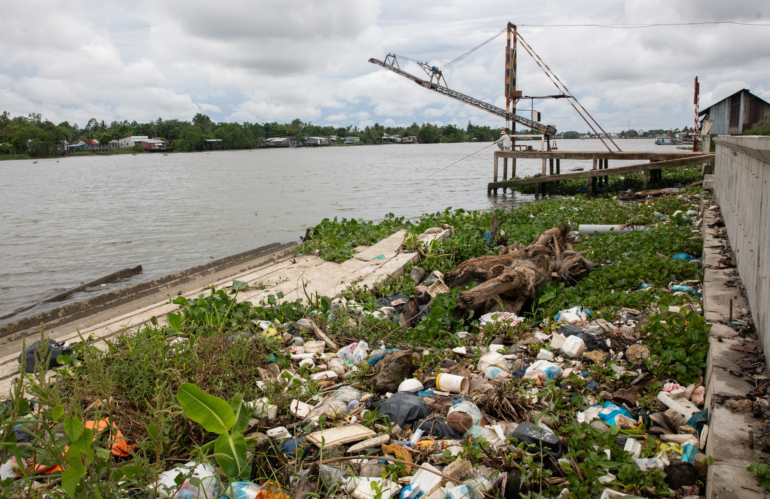 Plastics and other waste scattered along the riverbank 