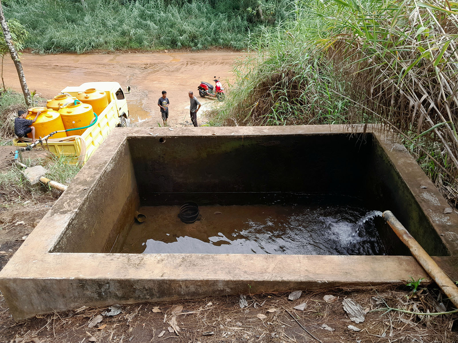 A truck collecting water from a reservoir at the foot of a hill
