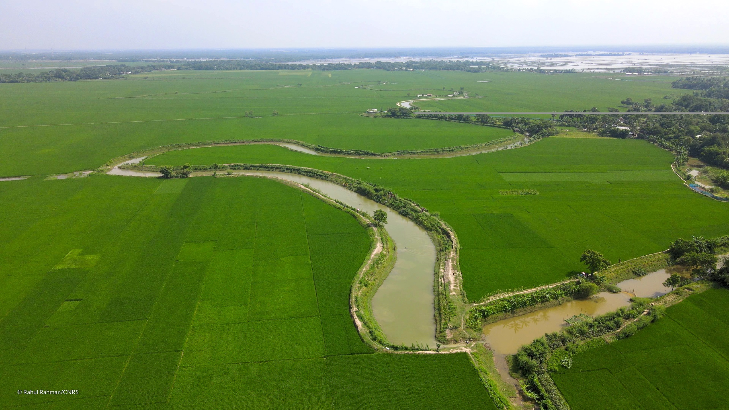 a winding river surrounded by green fields