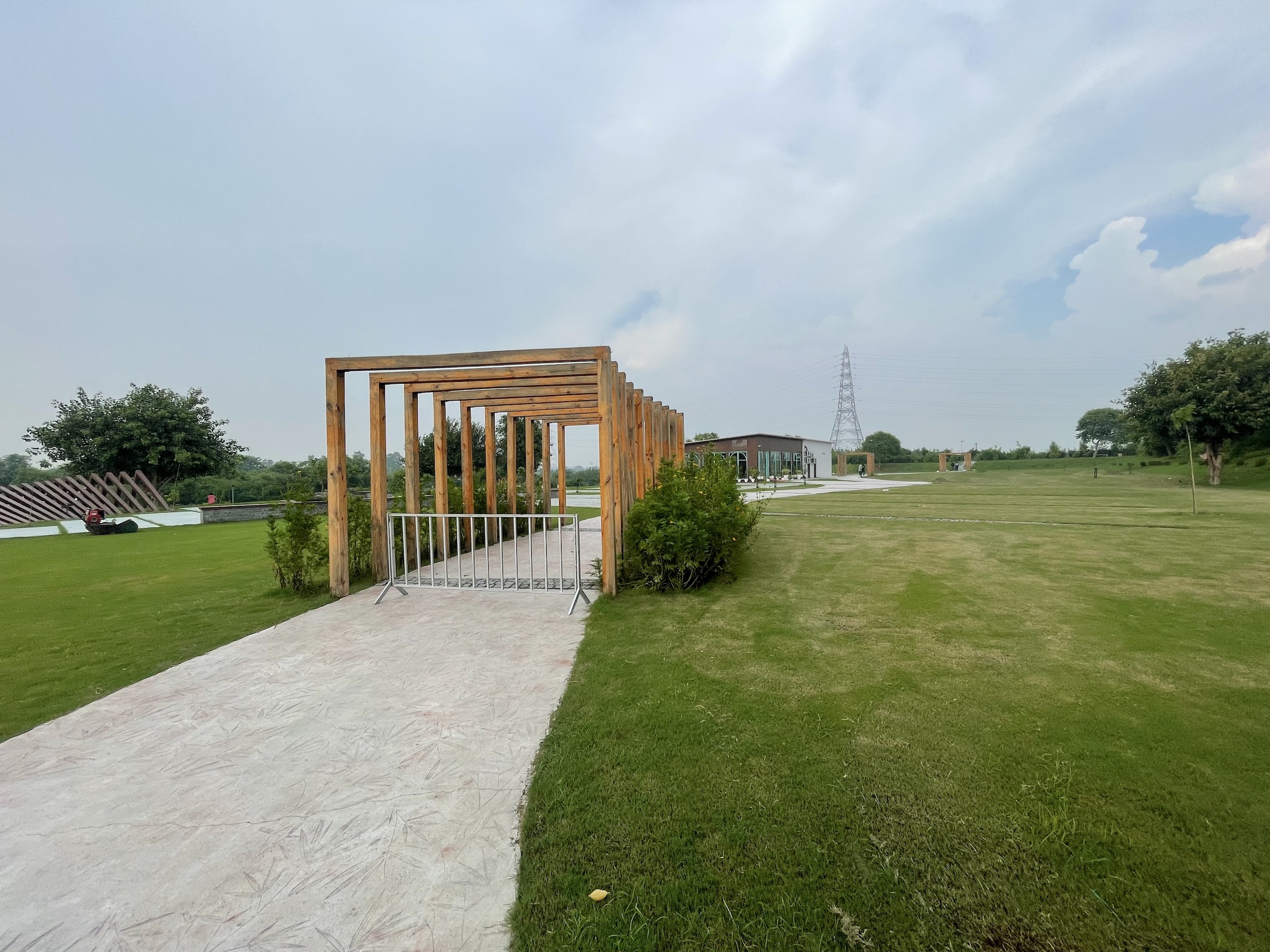 A wooden construction  alongside a pathway leads to a building 
