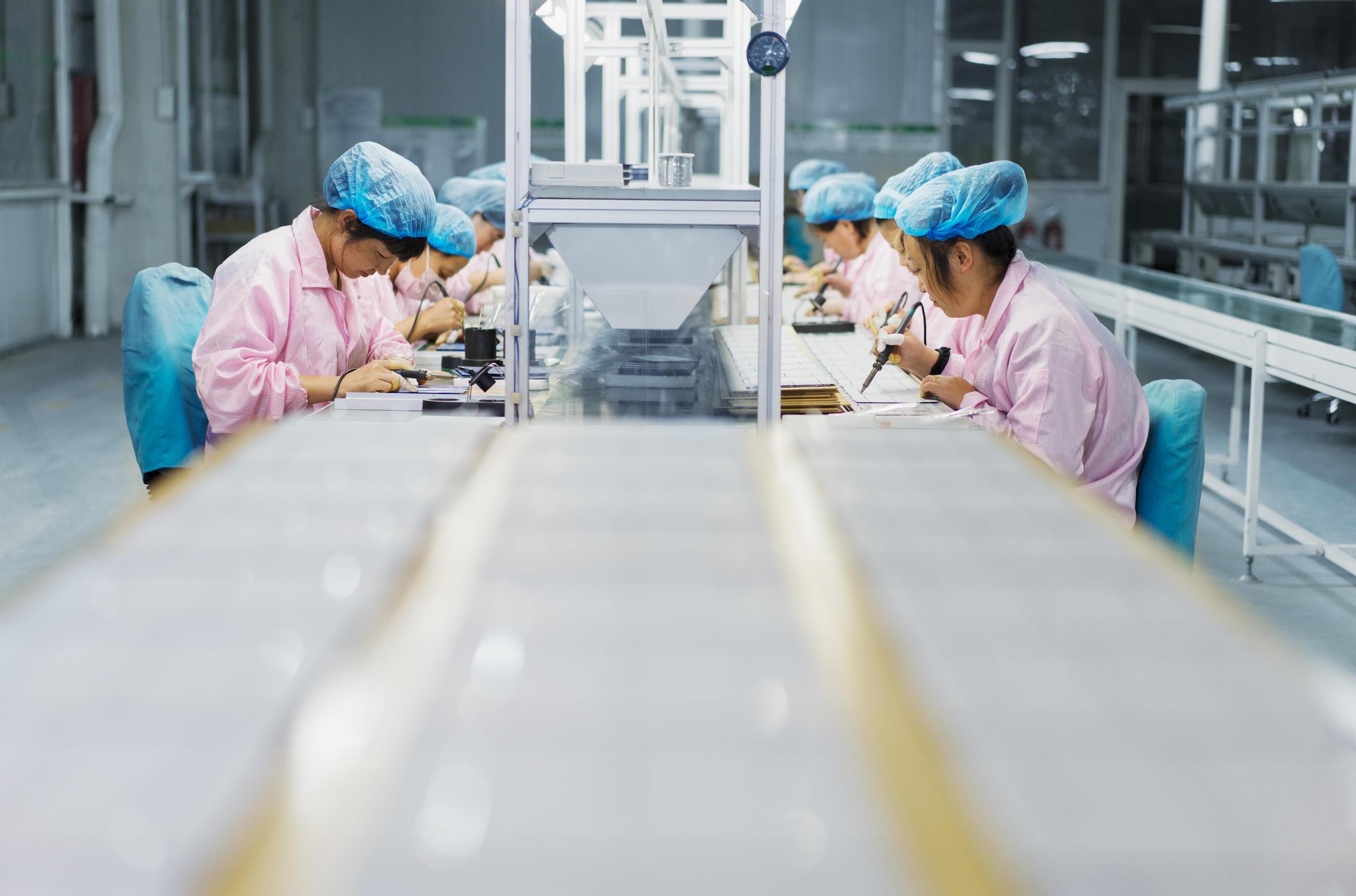 female workers assembling electronic components in a factory