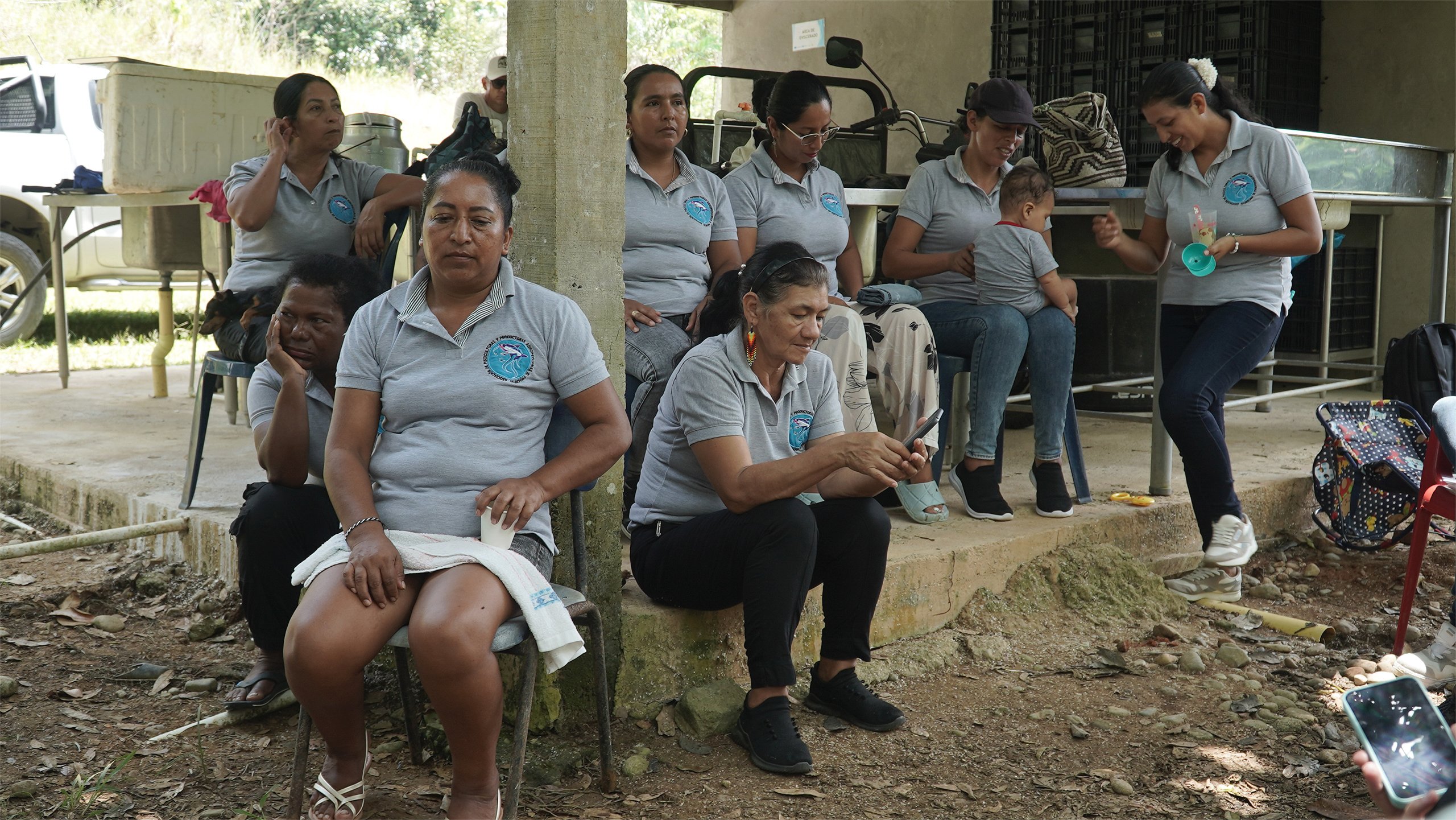 group of seated women wearing grey polo shirts