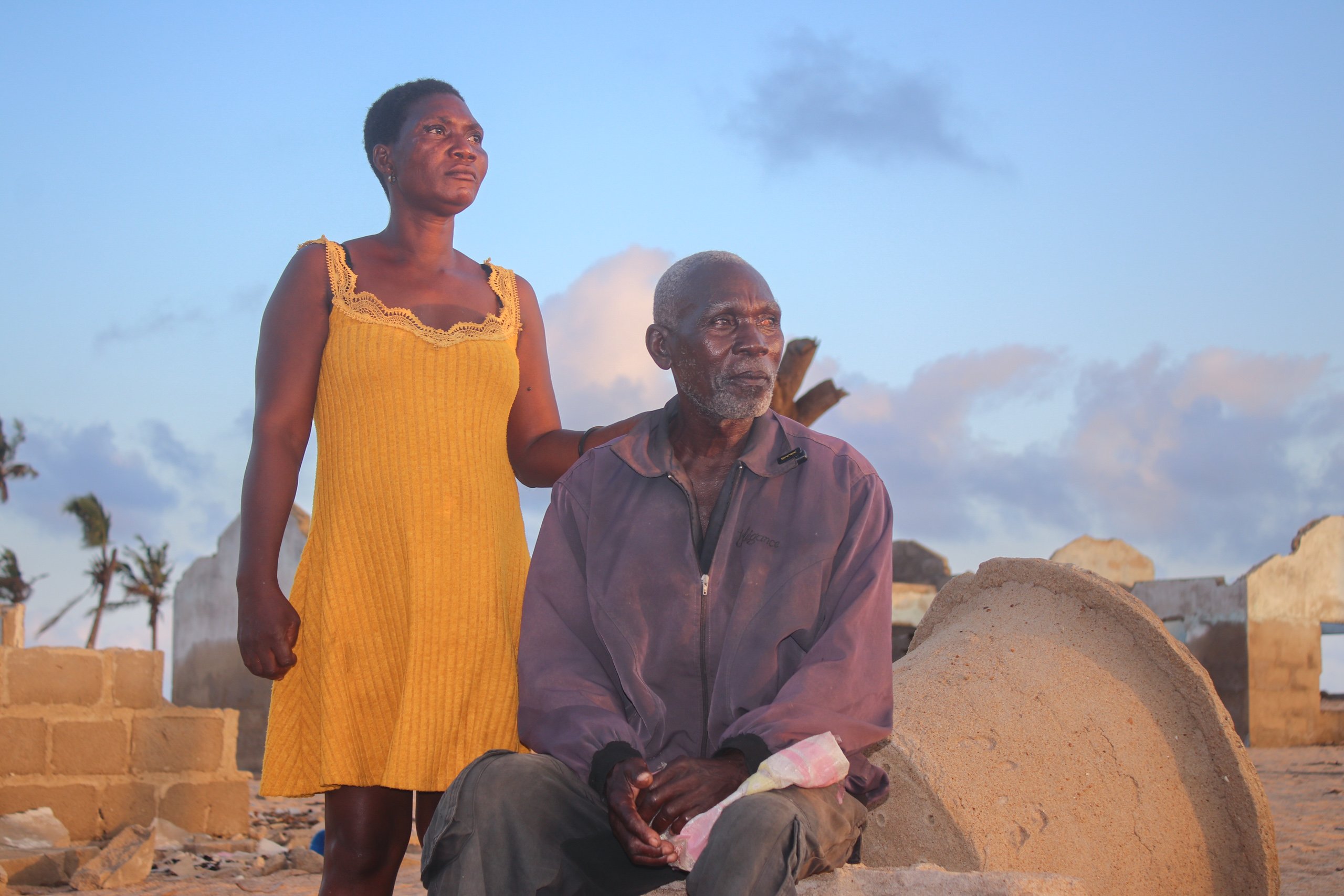 <p>Agbasa Stanley (right) and his daughter-in-law beside the collapsing houses of the late Dzakplagbe village, in Ghana’s south-eastern Volta region. The narrow strip of land that separates the Keta Lagoon from the Atlantic Ocean is gradually sinking (Image: Ibrahim Khalilulahi Usman)</p>