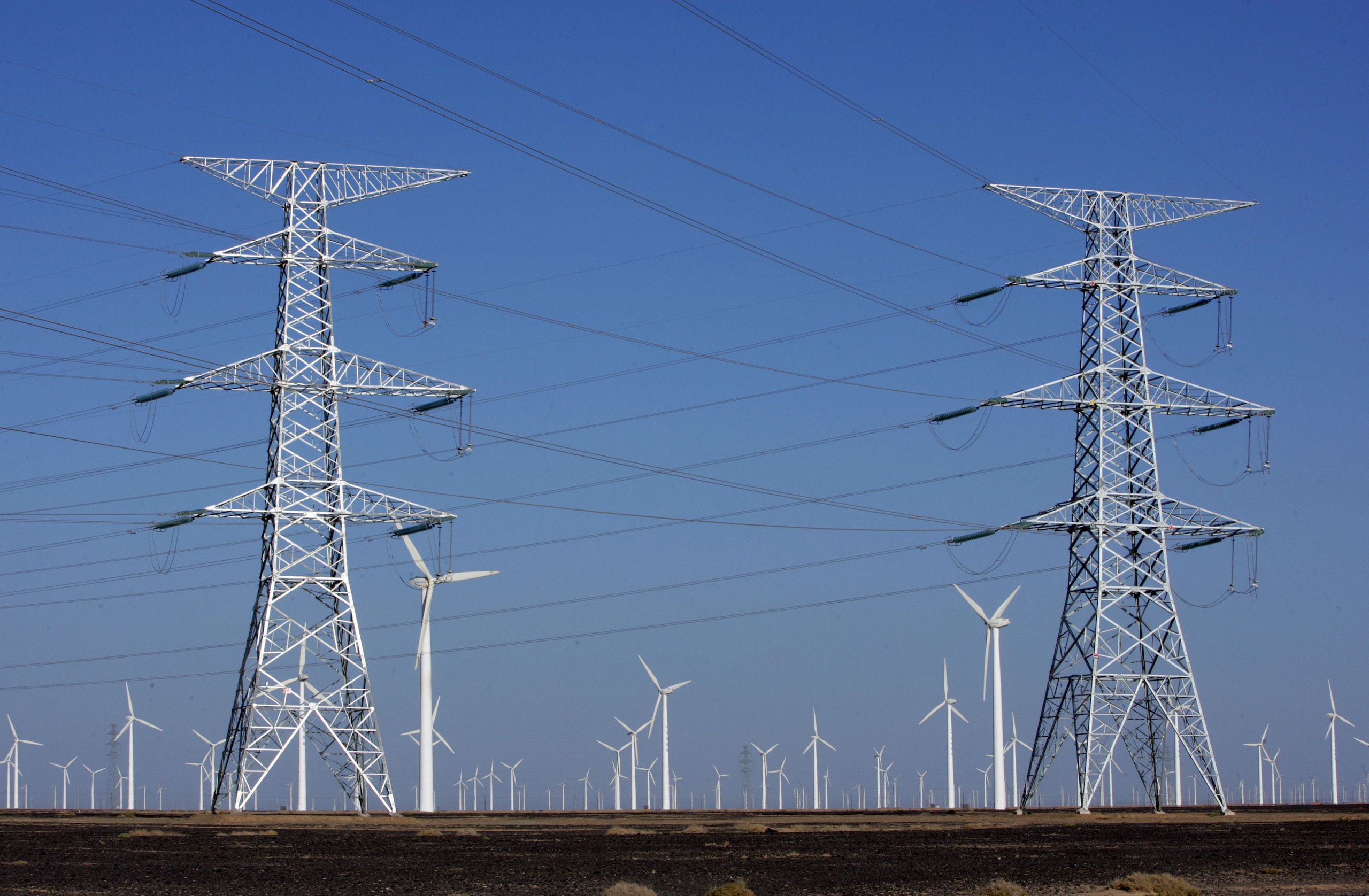 Power lines on pylons and wind turbines at a wind farm