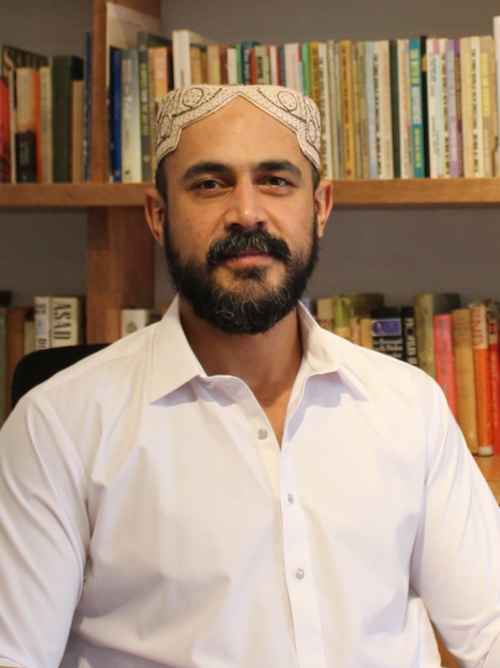 a man sitting in front of a bookshelf