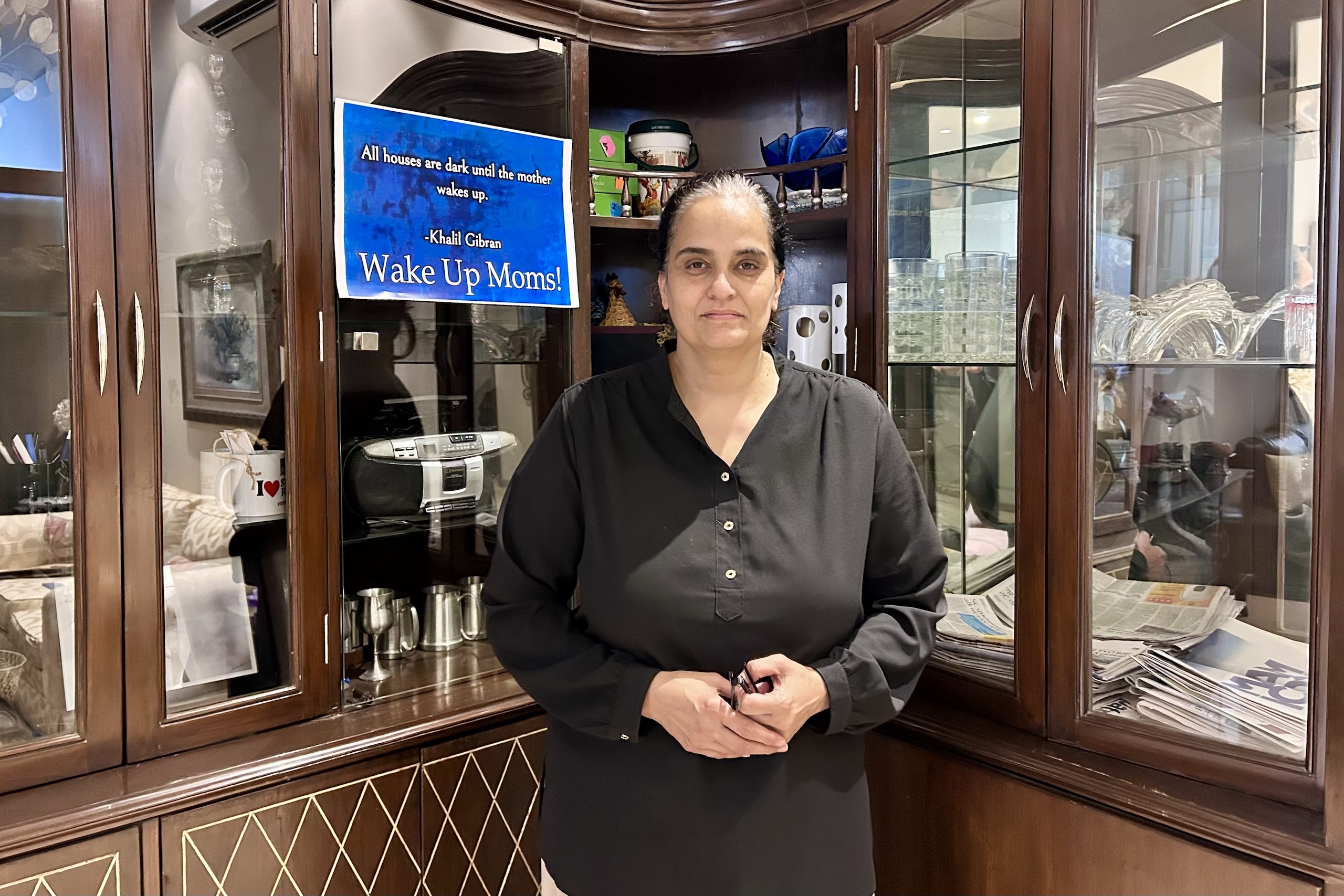 A woman stands in front of a display case