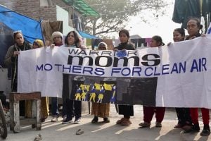 Women display a banner stating "Water Moms: No Mothers for Clean Air"